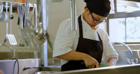 Focused Female Chef Preparing Vegetables in Professional Kitchen
