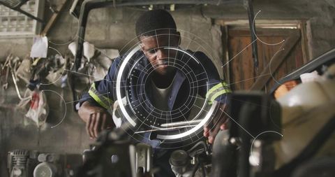 Mechanic diagnosing engine with augmented reality HUD while repairing vehicle in garage