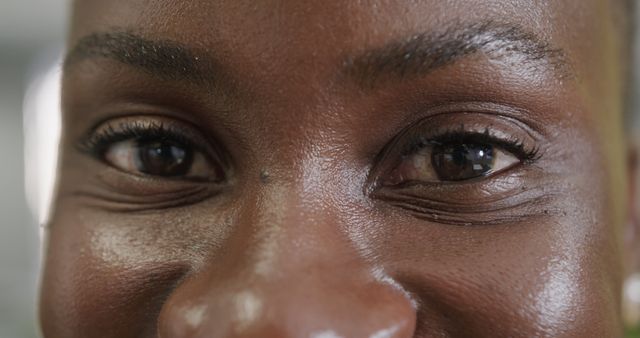Close up of eyes of happy african american casual businesswoman standing on office. Casual business, work and office, unaltered.