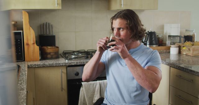 Man with long hair drinking coffee in kitchen - Download Free Stock Images Pikwizard.com