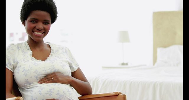 Smiling Pregnant Woman Sitting in Bedroom - Download Free Stock Images Pikwizard.com