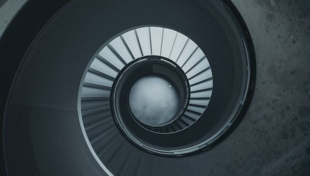 Abstract view of concrete spiral staircase with metal handrail