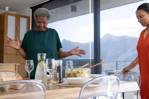 Senior african american women arranging dining table for relaxed mountain-view lunch