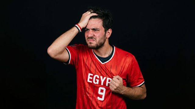 Egypt football fan expressing frustration clutching jersey and running hand through hair