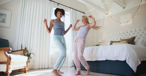 Joyful Friends Dancing Together in Stylish Bedroom Setting