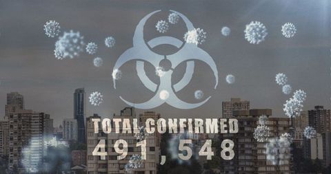 Biohazard sign with covid-19 cells overlaying cityscape
