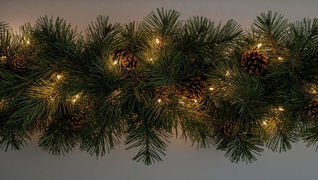 Festive pine garland with pinecones and warm white led lights for holiday decor