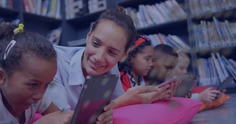 Teacher Guiding Students Using Tablets in Library, Collaborative Digital Learning Scene