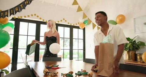 Diverse Friends Decorating Living Room for Birthday Celebration