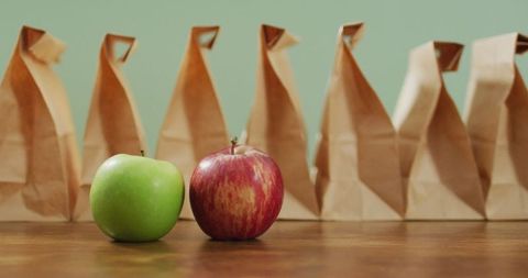 Apples with Brown Paper Lunch Bags on Wooden Table