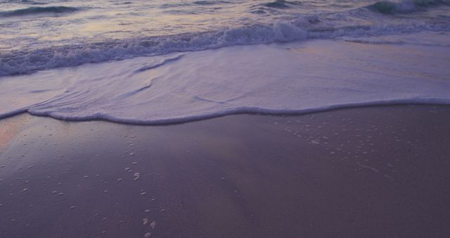 Sandy beach and calm sea with clear sky at sunset, shot in slow motion with copy space