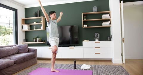 Young Man Practicing Yoga in Modern Living Room