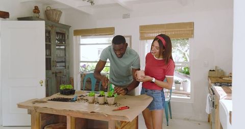 Smiling couple engaging in planting activity at home