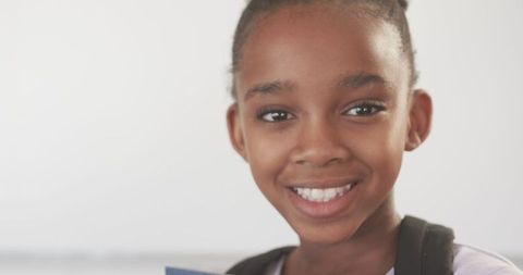 Smiling African American Girl Holding Notebook with Optimism