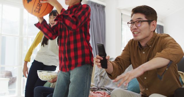 A family spending quality time together playing a video game in the living room. Parents and children are engaged and smiling, creating a lively atmosphere. The image can be used for promoting family bonding activities, home entertainment concepts, and advertisements for video game products.