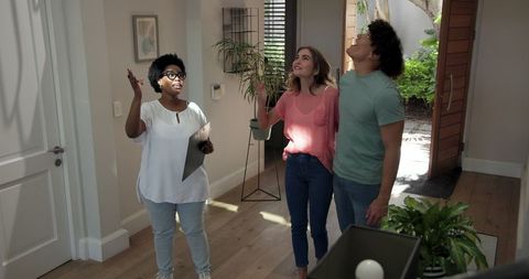 Realtor Presenting Home to Excited Young Couple