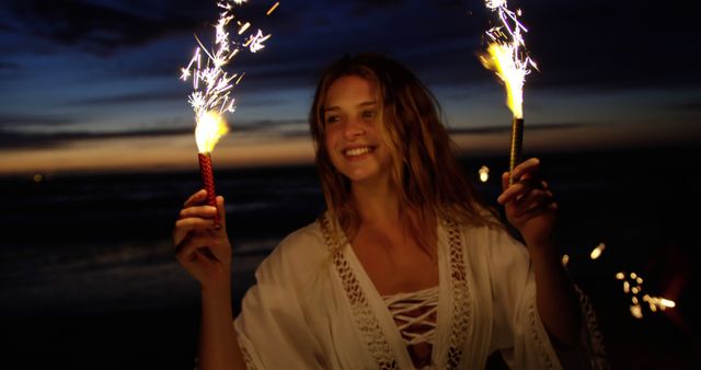 Joyful Woman with Sparklers Enjoying Beach at Dusk - Download Free Stock Images Pikwizard.com