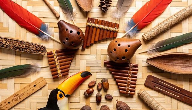 Arranging toucan carving, panpipes and ocarinas with colorful feathers on bamboo mat