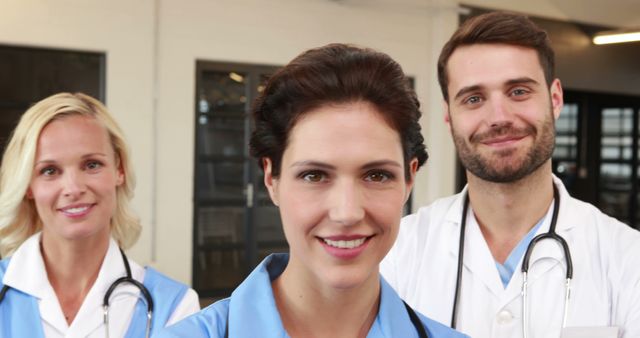 Group of healthcare professionals smiling and posing for camreshot. Women and man in medical uniforms and wearing stethoscopes. Perfect for healthcare, teamwork, hospital, and medical service-related content.