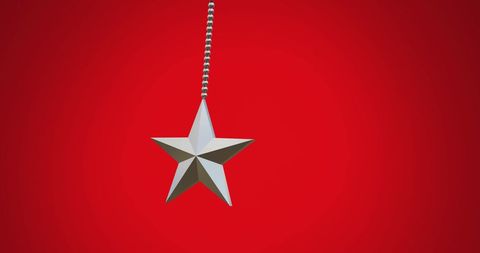 Hanging silver star ornament on vibrant red background