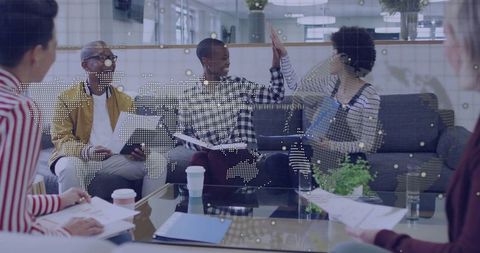 Diverse professionals celebrating team success in modern office