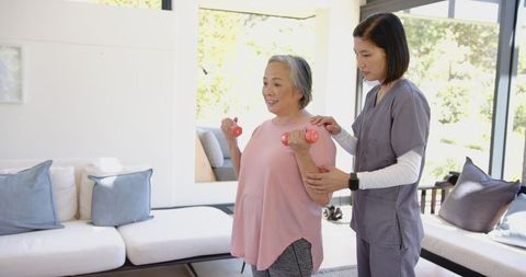 Senior Woman Exercising with Assistance from Professional Physiotherapist