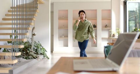 Asian Man Walking in Modern Home Office, Greenery and Minimalist Design