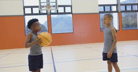 Active young basketball players show teamwork on indoor court