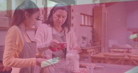 Woman and Teen Collaborating on Baking: Measuring, Pouring, Stirring in Sunlit Home Kitchen