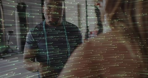 Trainer assessing client body measurements in gym environment