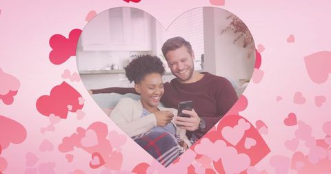 Diverse Couple Smiling Together with Smartphone at Home