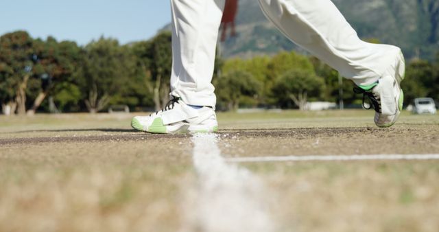 Close-Up of Cricketer Stepping Onto Pitch in White Uniform and Green Shoes - Download Free Stock Images Pikwizard.com