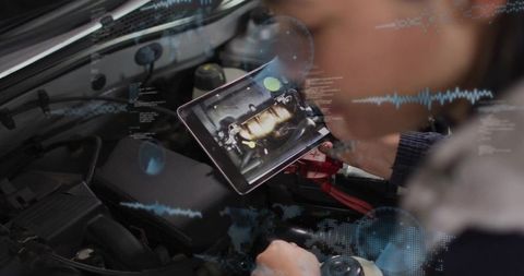 Technician diagnosing car engine using tablet with augmented reality overlays