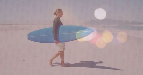 Mature surfer walking on tranquil beach with surfboard