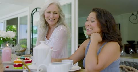 Women Enjoying Tea and Pastries in Relaxing Home Environment