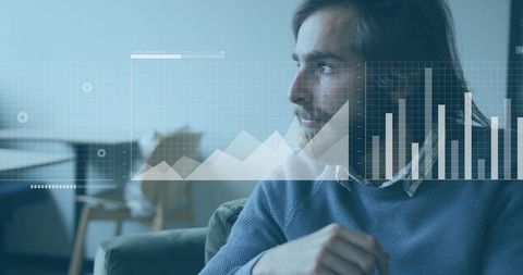 Man studying digital financial charts overlay while sitting on sofa in modern lounge