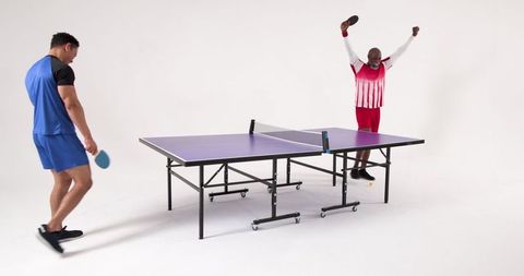 Diverse athletes competing in intense table tennis match