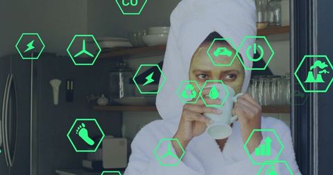 Sipping morning tea wearing robe and face mask in modern eco-friendly kitchen