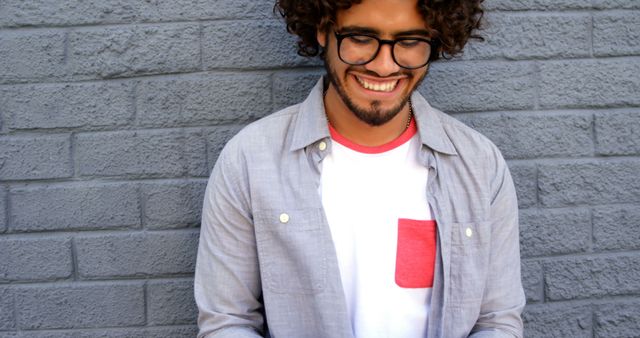 Smiling Young Man Using Smartphone Against Brick Wall - Download Free Stock Images Pikwizard.com