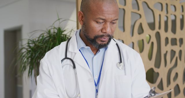 African American Doctor Reviewing Patient Chart Wearing Stethoscope - Download Free Stock Images Pikwizard.com