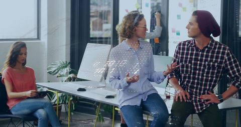 Creative team discussing ideas in modern office with urban view
