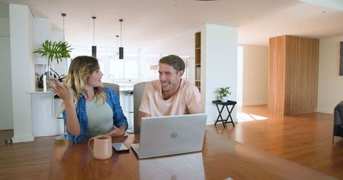 Couple Discussing Plans Using Laptop at Home