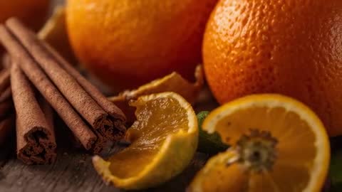 Close-up video showing oranges and cinnamon sticks on rustic wooden table, citrus spice