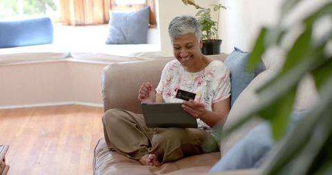 Senior Woman Shopping Online from Home Tablet on Couch