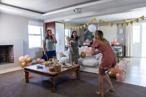 Women Having Party in Living Room with Snacks and Decorations