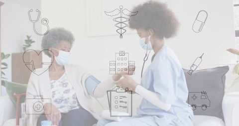 Measuring blood pressure during homecare visit nurse in blue scrubs wearing mask with elderly patien