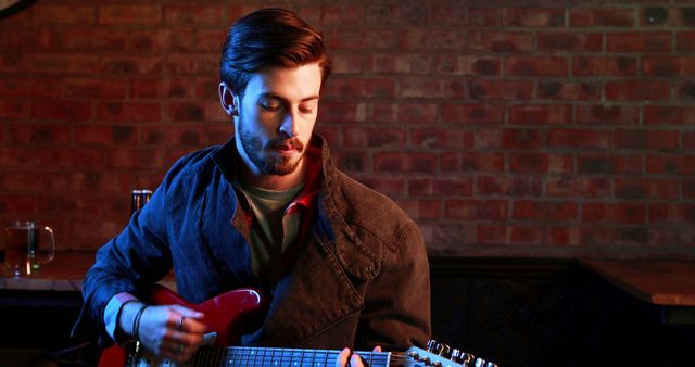 Young Man Playing Electric Guitar in Dimly Lit Room - Download Free Stock Images Pikwizard.com