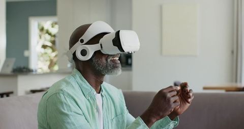 Mature African American Man Exploring Virtual Reality at Home with White VR Headset