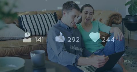Young couple engaging with social media on laptop at home
