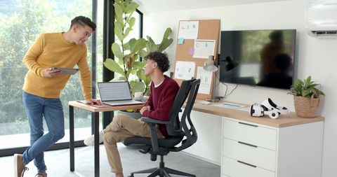 Young Male Coworkers Collaborating on Innovative Project in Modern Office